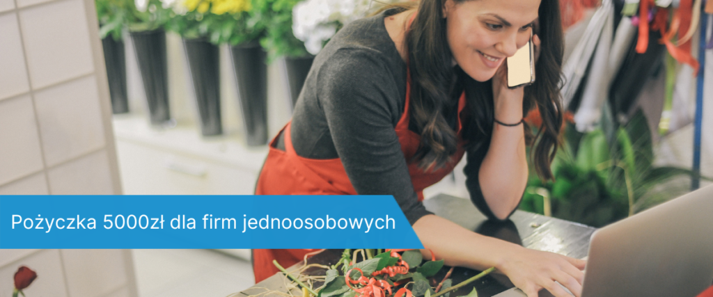 Florystka w czerwonym fartuchu rozmawia przez telefon i korzysta z laptopa przy ladzie w kwiaciarni