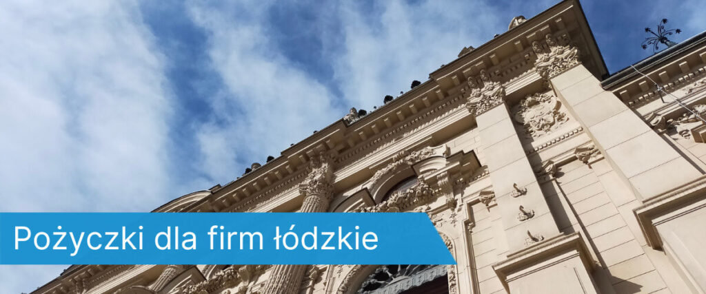 budynek z bogato zdobioną fasadą widziany z dołu, na tle niebieskiego nieba z chmurami